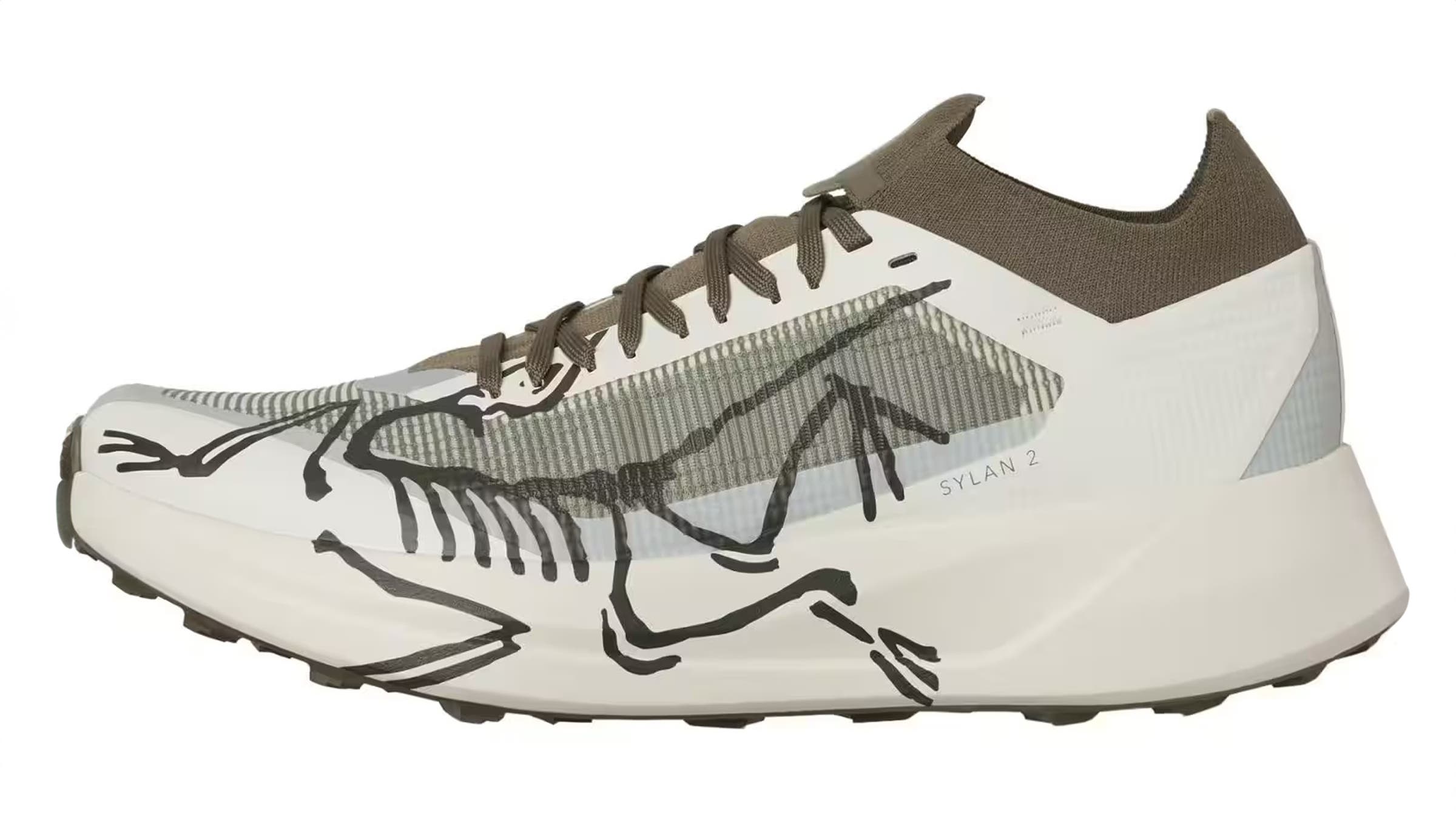 Arc'teryx Sylan 2 trail running shoe in white and olive green, featuring a skeletal bird graphic across the upper. This lightweight footwear is built for high-speed mountain fastpacking across technical terrain.